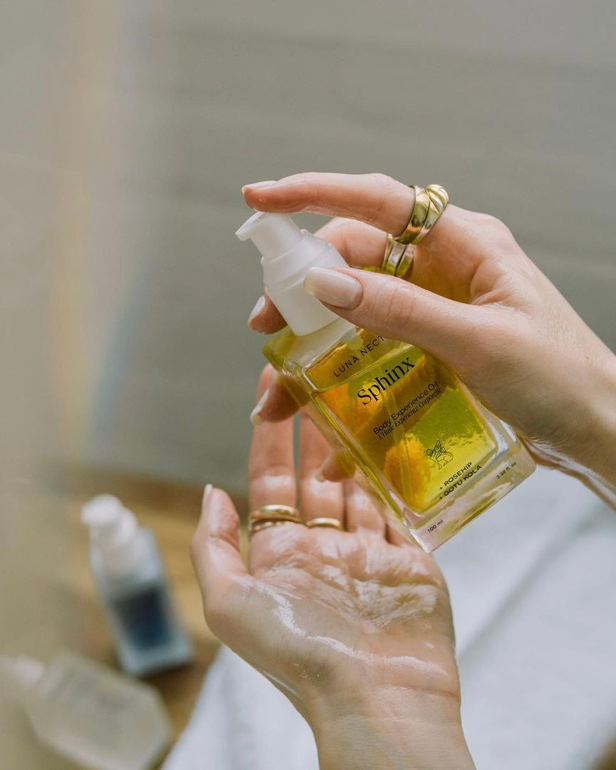 Woman holding Sphinx Body Oil with soft, hydrated hands - natural fall skincare hydration