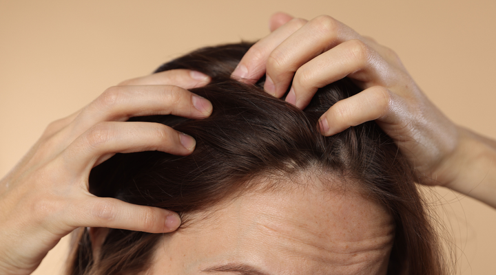 Woman examining hairline showing visible thinning with age